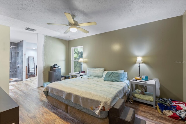 bedroom featuring ceiling fan, a textured ceiling, and wood-type flooring