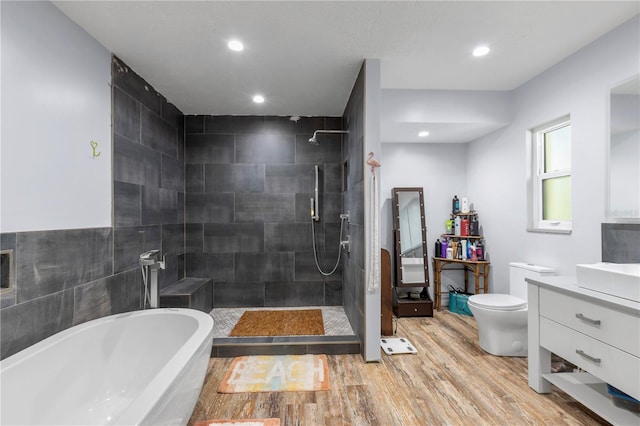 full bathroom featuring hardwood / wood-style floors, plus walk in shower, toilet, and vanity