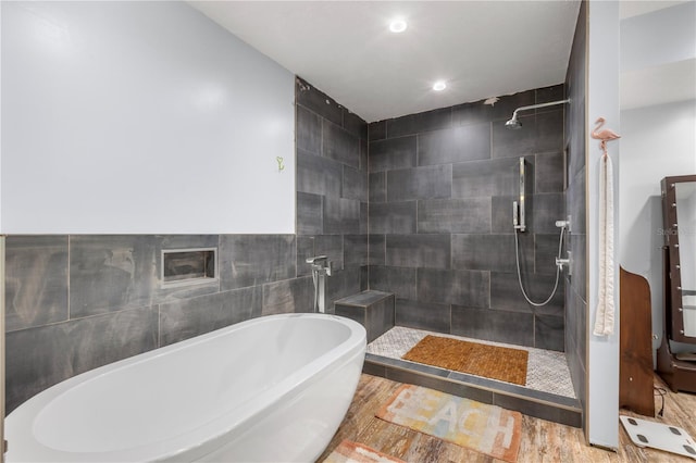 bathroom with independent shower and bath and hardwood / wood-style floors