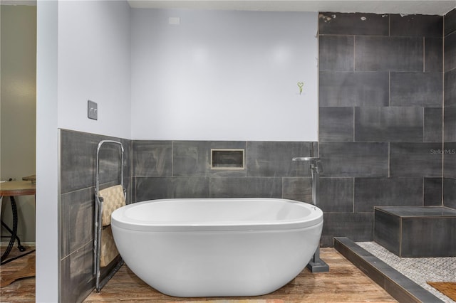 bathroom featuring tile walls, walk in shower, and wood-type flooring