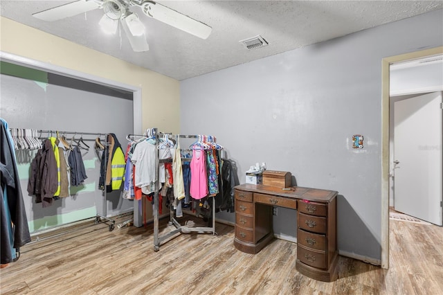 walk in closet with ceiling fan and hardwood / wood-style flooring