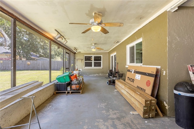 unfurnished sunroom with ceiling fan