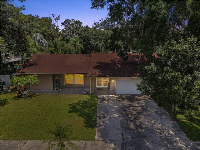 view of front of property featuring a garage and a lawn