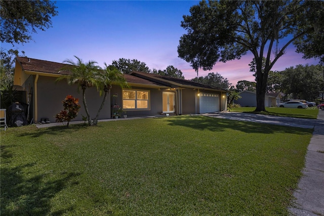 single story home featuring a yard and a garage