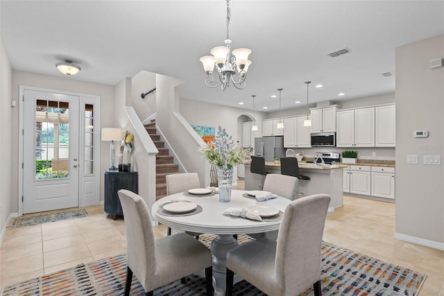 tiled dining space featuring a notable chandelier