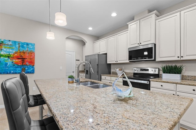 kitchen featuring white cabinetry, pendant lighting, an island with sink, and stainless steel appliances