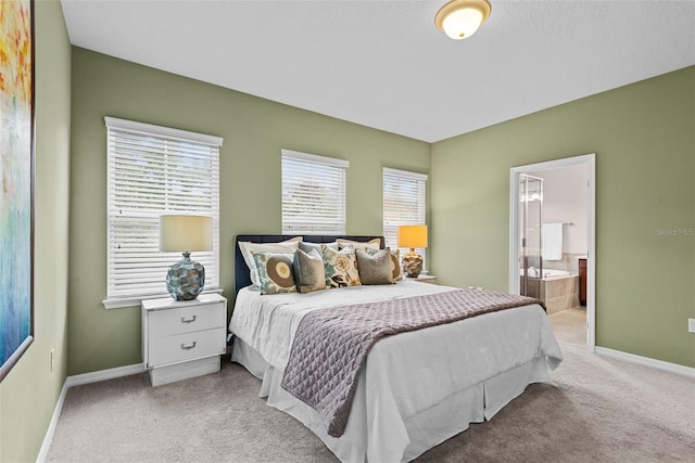 carpeted bedroom featuring ensuite bathroom and multiple windows