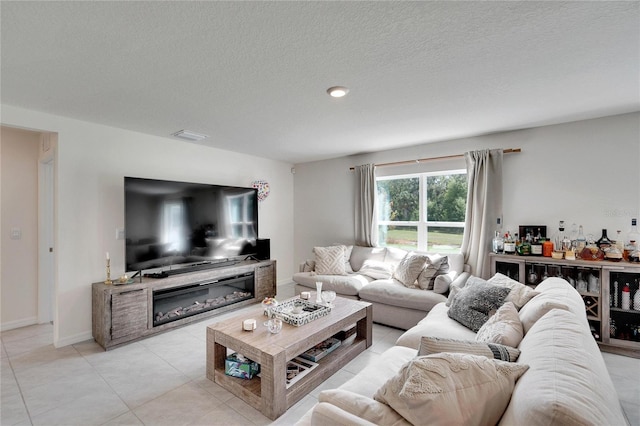 tiled living room featuring a textured ceiling and indoor bar