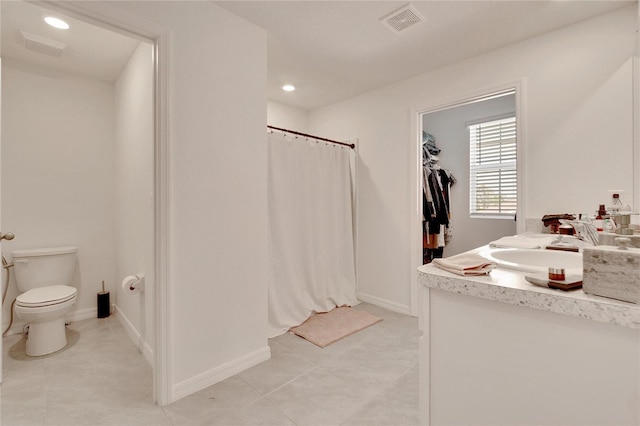 bathroom with vanity, tile patterned flooring, and toilet