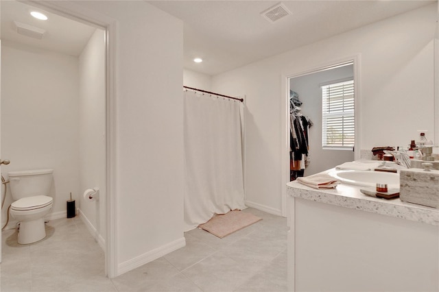 bathroom with walk in shower, vanity, toilet, and tile patterned flooring