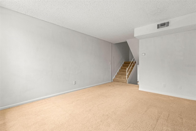 unfurnished room featuring a textured ceiling and carpet floors