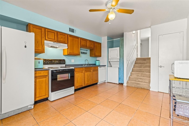 kitchen featuring white appliances, light tile patterned floors, stacked washer / drying machine, sink, and ceiling fan