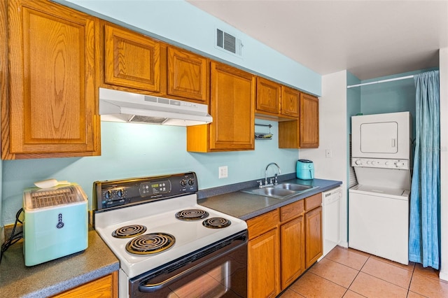 kitchen featuring white appliances, light tile patterned flooring, sink, and stacked washer and dryer