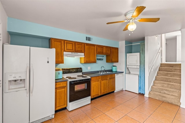 kitchen with white appliances, sink, stacked washer / dryer, light tile patterned flooring, and ceiling fan