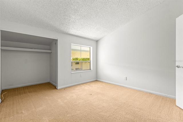 unfurnished bedroom with a textured ceiling, light colored carpet, and a closet