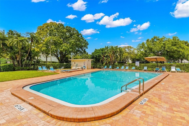 view of swimming pool with a patio area and a yard