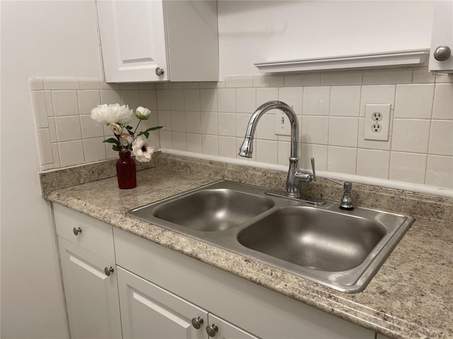 kitchen with sink, tasteful backsplash, white cabinets, and water heater