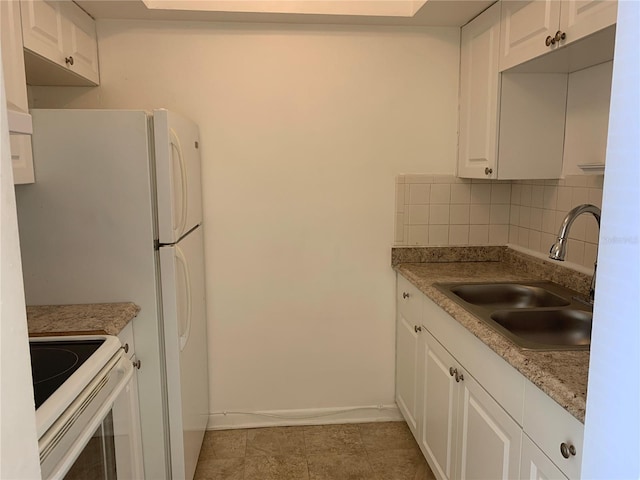 kitchen with range, tasteful backsplash, white cabinets, and tile patterned floors