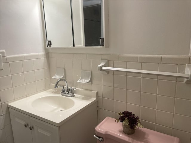 bathroom featuring vanity, tasteful backsplash, toilet, and tile walls