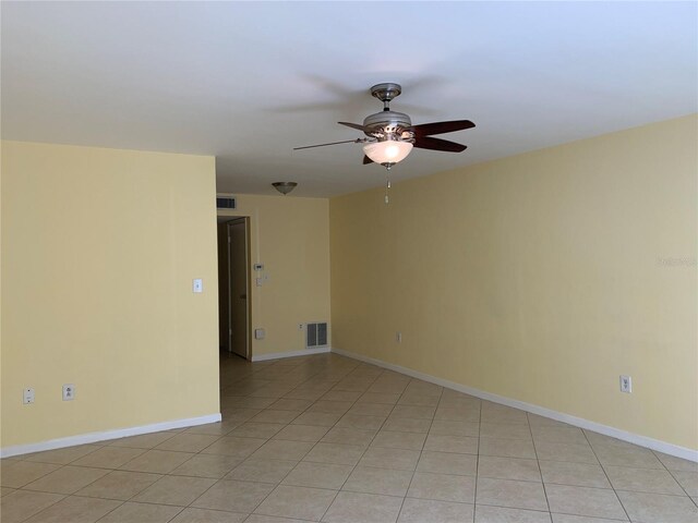 tiled spare room featuring ceiling fan