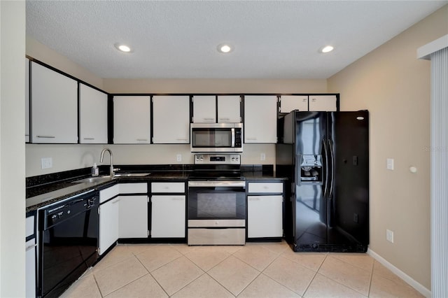 kitchen featuring light tile patterned floors, black appliances, a sink, and white cabinetry