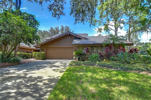 ranch-style home featuring a garage and a front lawn