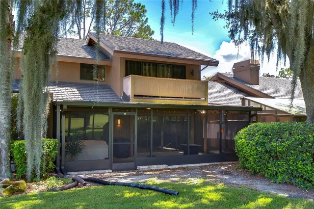 rear view of property featuring a sunroom