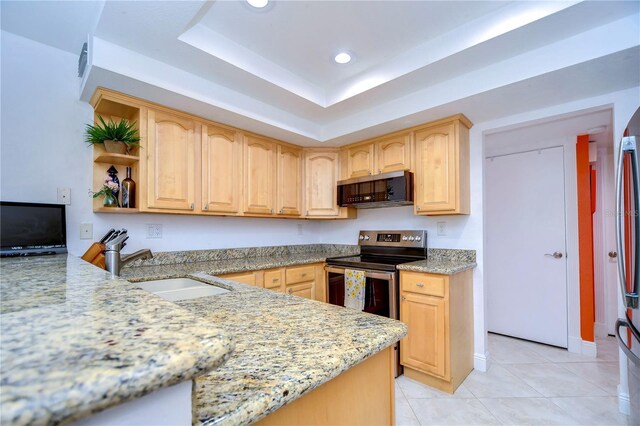 kitchen featuring stainless steel appliances, light stone countertops, light tile patterned floors, and a raised ceiling