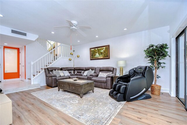 living room with light hardwood / wood-style flooring and ceiling fan