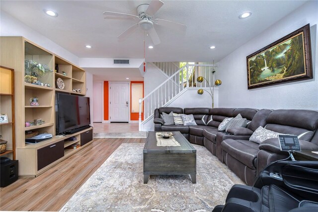 living room featuring light hardwood / wood-style flooring and ceiling fan