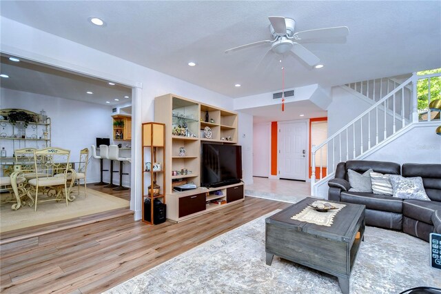 living room with ceiling fan and light hardwood / wood-style floors