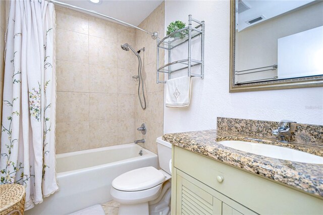 full bathroom featuring vanity, shower / bath combo with shower curtain, tile patterned flooring, and toilet