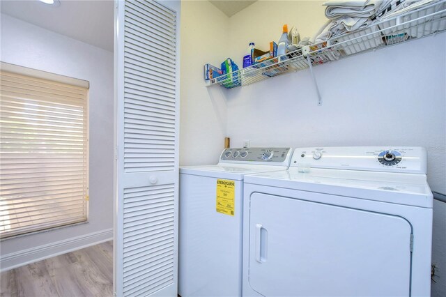 laundry room with light hardwood / wood-style flooring and washer and dryer