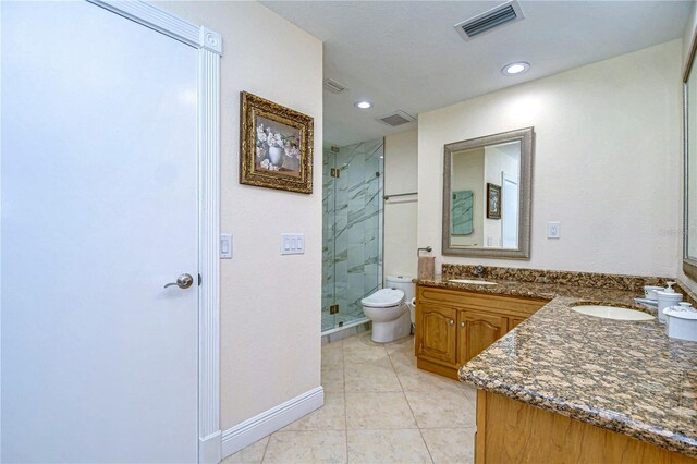 bathroom with vanity, tile patterned floors, toilet, and an enclosed shower