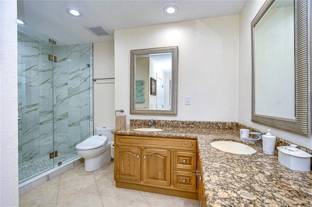 bathroom featuring a shower with shower door, tile patterned floors, double vanity, and toilet