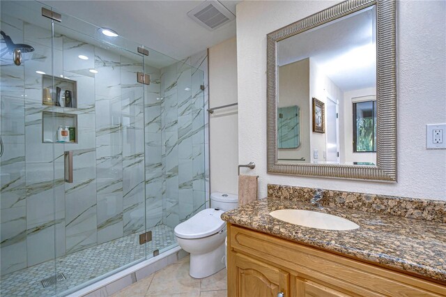 bathroom featuring a shower with door, vanity, tile patterned flooring, and toilet