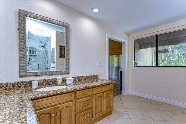 bathroom with tile patterned flooring, a shower, and vanity