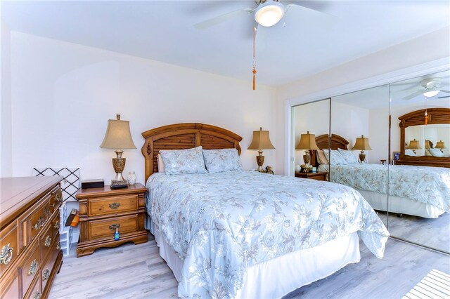 bedroom featuring ceiling fan, light wood-type flooring, and a closet