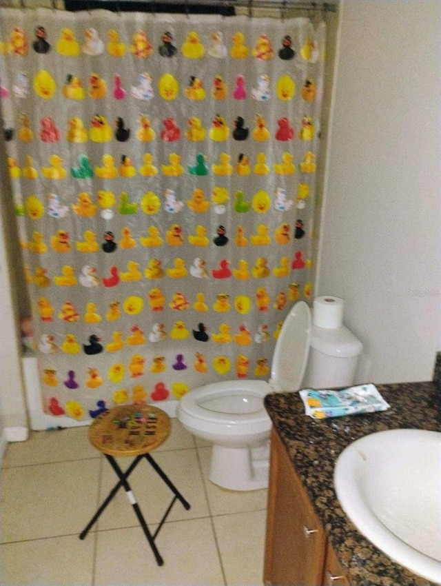 bathroom featuring curtained shower, vanity, toilet, and tile patterned floors