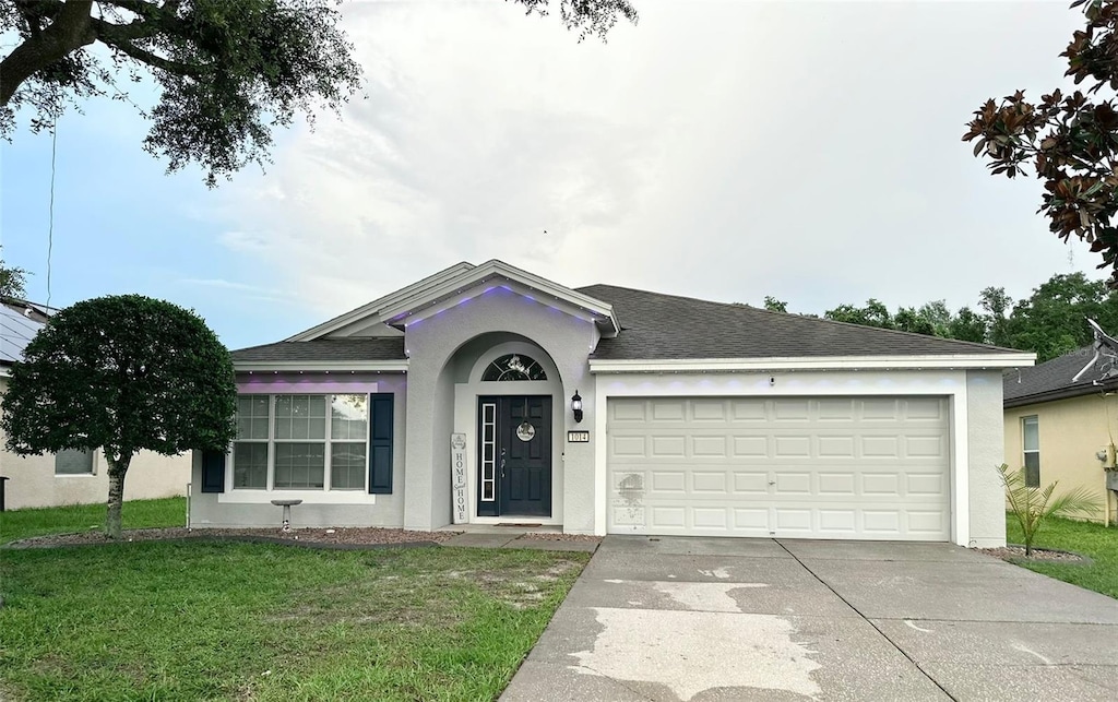 single story home featuring a front yard and a garage