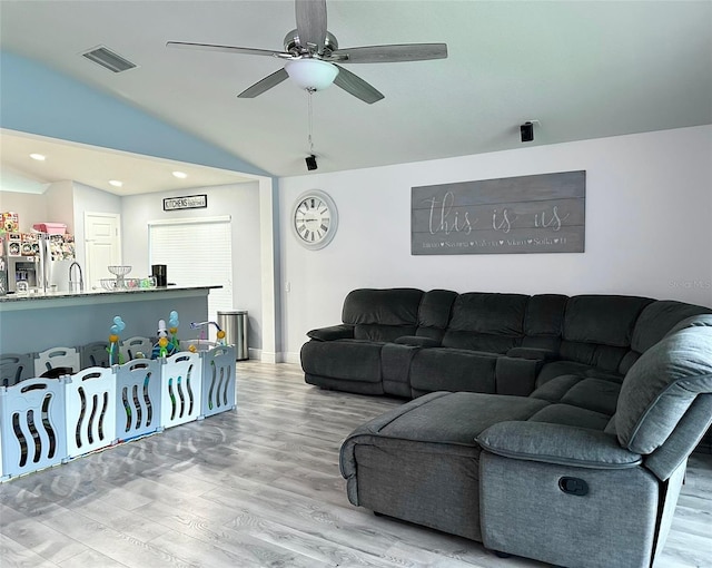 living room featuring ceiling fan, lofted ceiling, and hardwood / wood-style floors