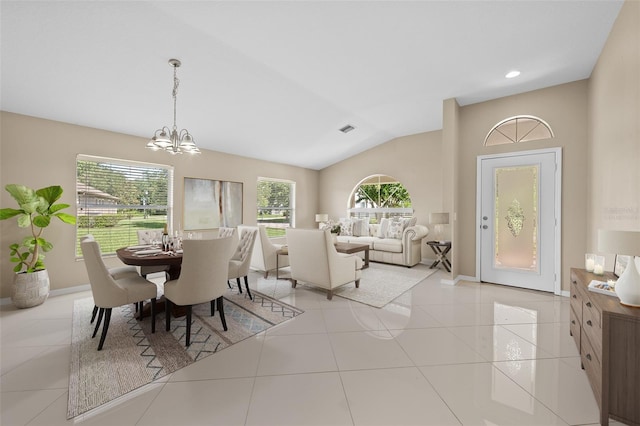 tiled dining room with a notable chandelier, a healthy amount of sunlight, and lofted ceiling