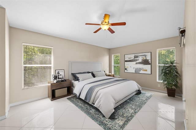 bedroom featuring multiple windows, ceiling fan, and light tile patterned floors