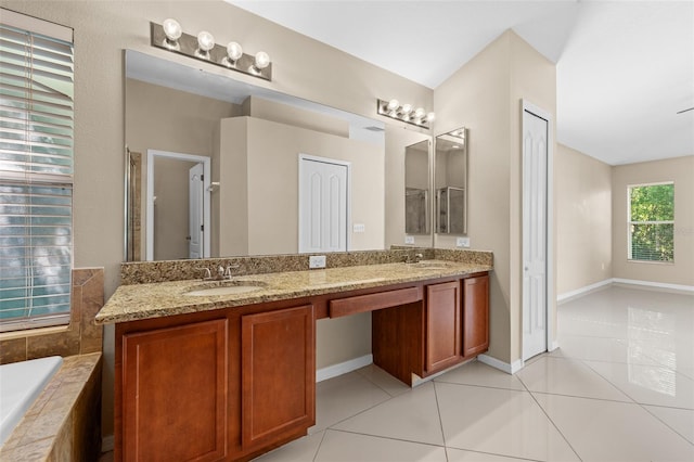 bathroom with tiled bath, tile patterned floors, and double sink vanity