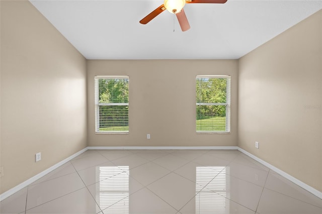 tiled spare room with a healthy amount of sunlight and ceiling fan