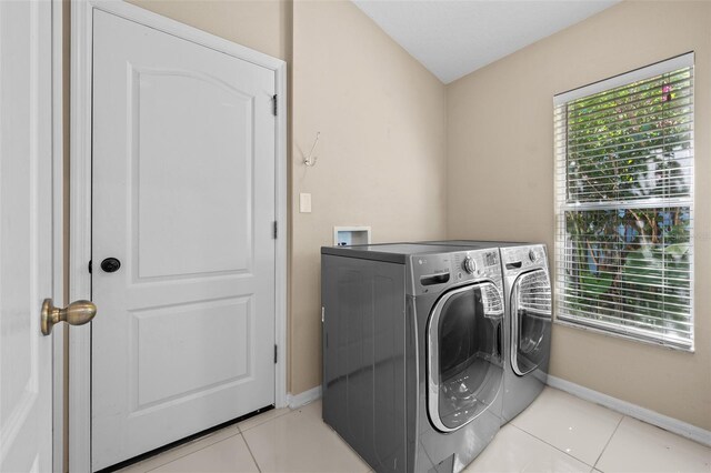 laundry room with light tile patterned flooring and washer and dryer