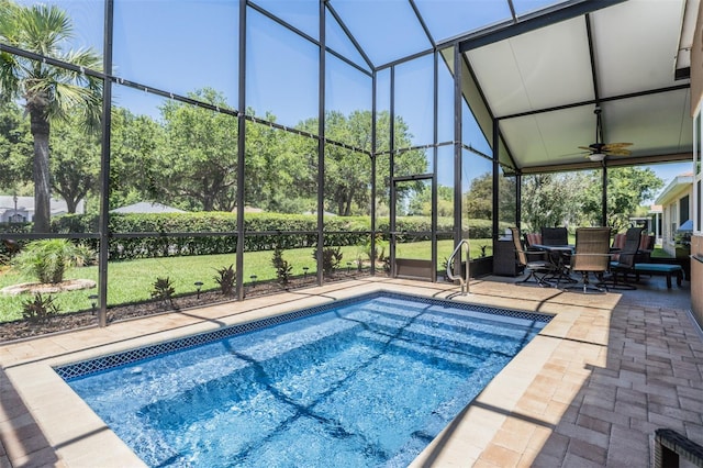 view of pool featuring ceiling fan, glass enclosure, and a patio area