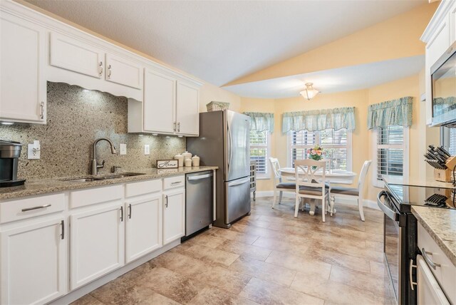 kitchen with backsplash, white cabinetry, light stone countertops, light tile patterned floors, and stainless steel appliances