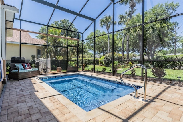 view of pool with glass enclosure and a patio area