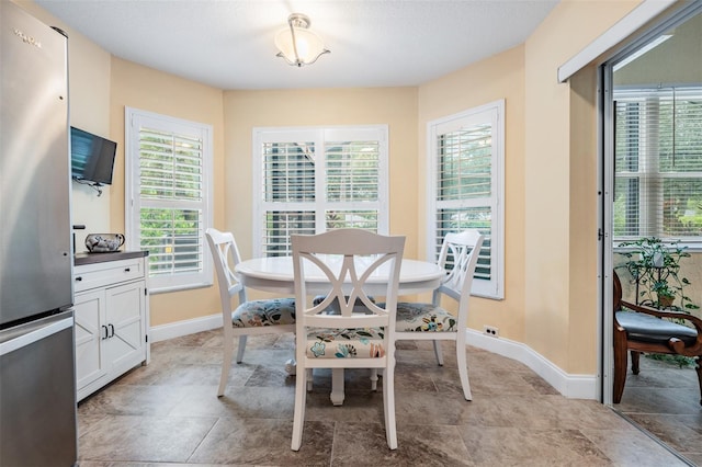 tiled dining space featuring a wealth of natural light